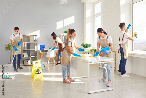 Cleaner group working, professional janitor service busy completing cleaning tasks at home, office. Young active people employed to take care of room, company maintaining washing, dusting, mopping 
