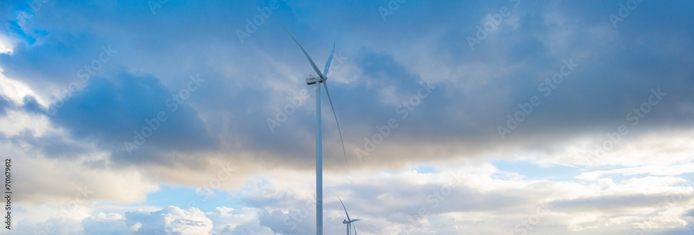 White and grey clouds in a blue sky over wind turbines in winter, Almere, Flevoland, Netherlands, January 1, 2024 White and grey clouds in a blue sky over wind turbines in winter, Almere, Flevoland, Netherlands, January 1, 2024