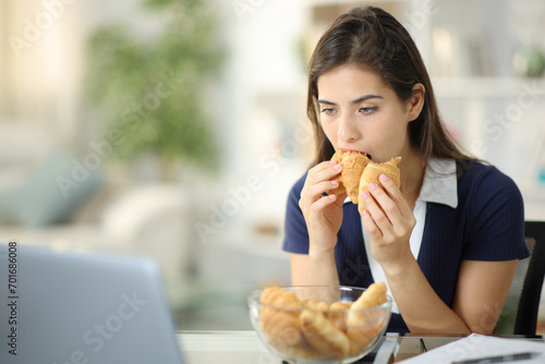 Discouraged anxious woman eating bakery photo