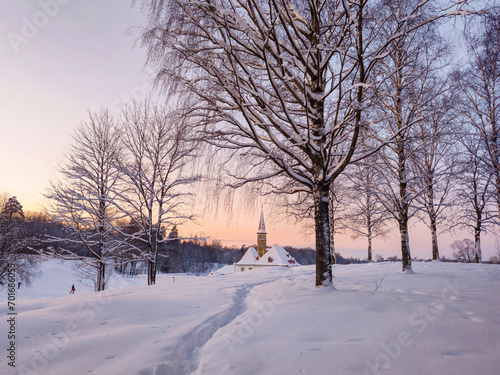 Sunny winter frosty sunset. Evening snowy landscape with old Maltese palace in beautiful natural landscape. Path through the snowdrifts. Gatchina. Russia.
