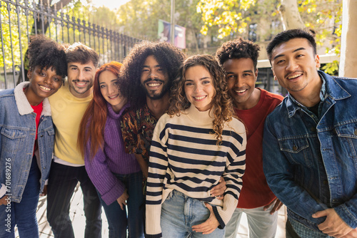 portrait of multiracial group of smiling friends looking at camera on city streets photo