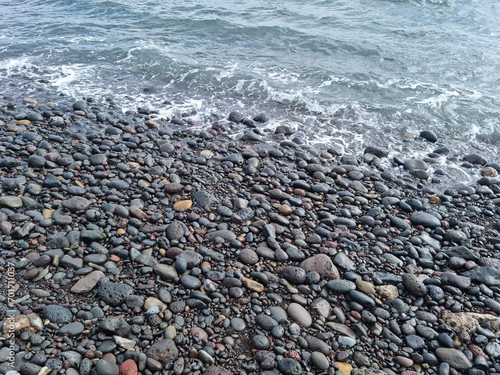 Jeju Island beach with round basalt rocks.
Jeju Island beach with round basalt rocks.