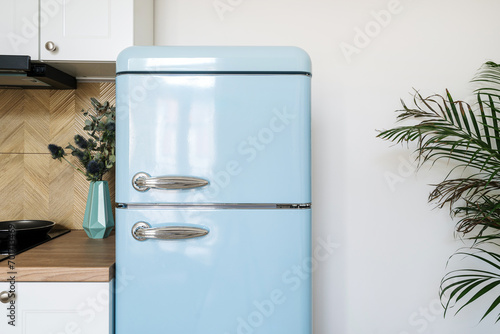 Blue refrigerator with stainless steel handles in retro style in kitchen photo