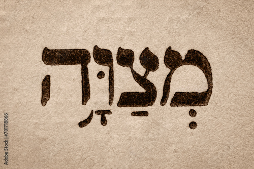 Single hebrew word Mitzvah on page of old Torah book. English translation is commandment commanded by God to be performed as a religious duty. Hebrew script. Closeup. photo