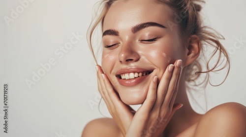Skincare. Woman with beautiful face touching healthy facial skin. Woman smiling while touching her flawless glowy skin with copy space for your advertisement, skincare