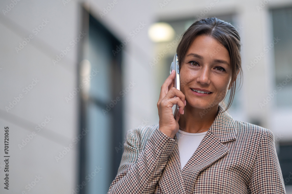 Woman making business call on cell on town street outdoors. Woman making business call on cell on town street outdoors.