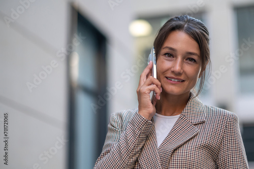 Woman making business call on cell on town street outdoors.