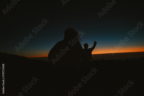 silhouette of young teens running to the sundown photo