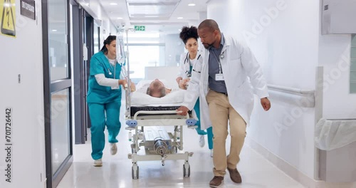 People, doctor and team running with bed for emergency, ICU or surgery to save life at hospital. Medical group, surgeon and nurse in hallway rush with stretcher for ER healthcare, urgency or support photo