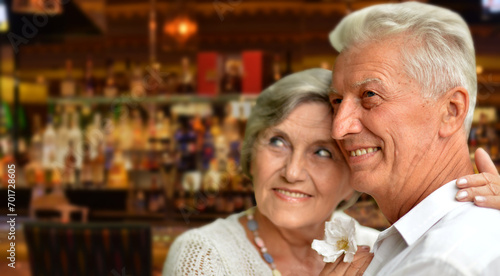 Happy old couple posing on blurred casino hall background