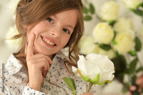 Pretty little girl smiling and posing with flowers