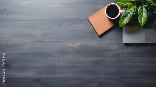 An office desk with a laptop and copy space in the background is captured in a flat lay photo.