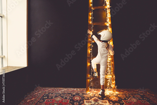 Astronaut futuristic kid girl with white full length uniform and helmet wearing silver shoes photo