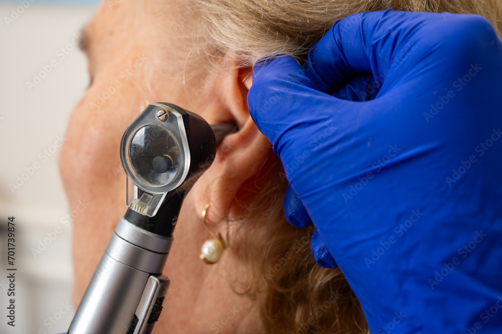 Office of an otolaryngologist, examination of an elderly woman's ear, ear plug, hearing test, doctor's examination