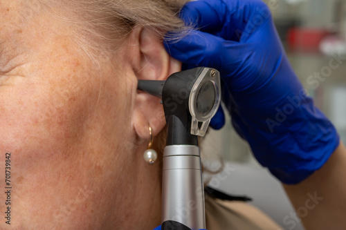 Otolaryngologist's office, doctor's examination of an elderly woman's ear, ear plug, hearing test