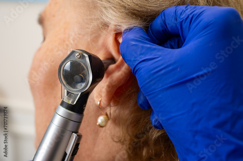 Obraz na płótnie Office of an otolaryngologist, examination of an elderly woman's ear, ear plug, hearing test, doctor's examination w salonie