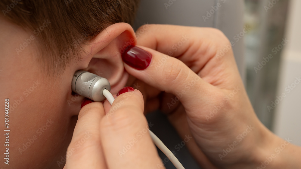 Fototapeta premium close view, otolaryngologist's office, ear examination of a girl, a boy, ear plug, hearing test, ultrasound, doctor's examination