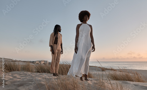 Black couple standing far apart on sandy shore