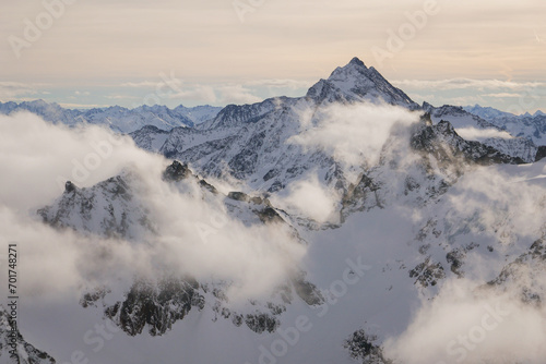 sunrise at snow covered misty mountain Alps in winter, Mount Titlis, Engelberg, Switzerland photo