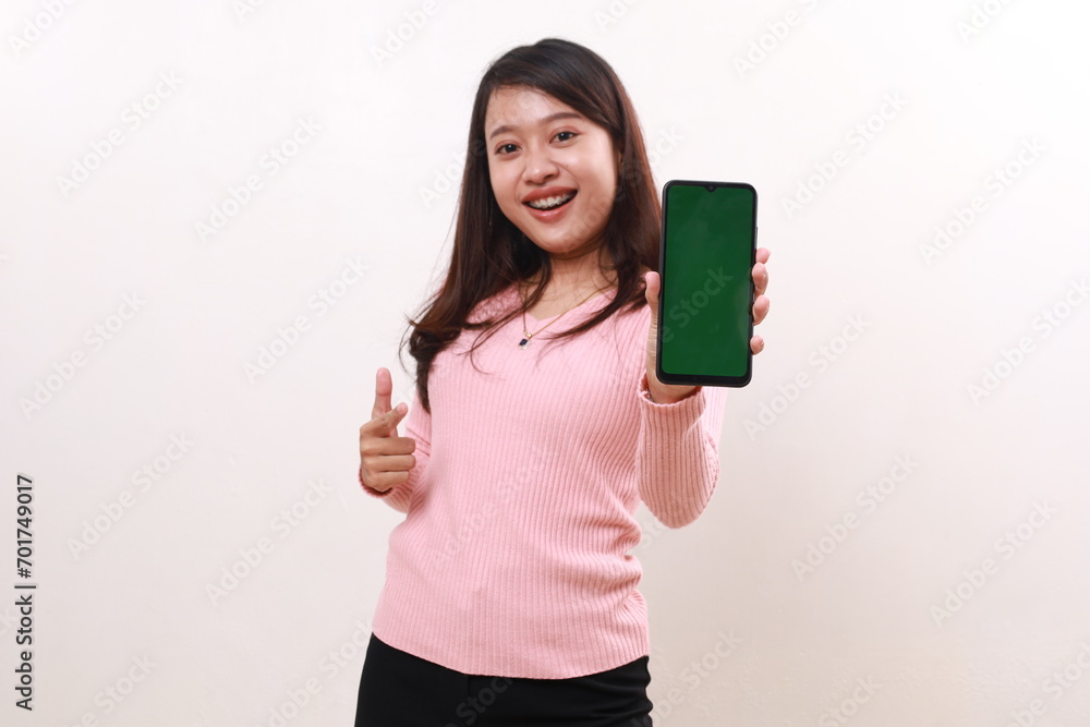 Happy young asian girl showing a blank cell phone screen, selective focus on phone. Isolated on white background Happy young asian girl showing a blank cell phone screen, selective focus on phone. Isolated on white background
