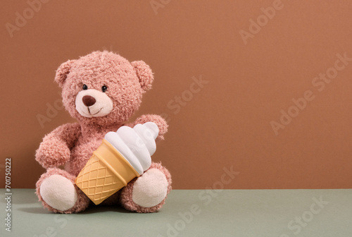 Soft teddy bear and ice cream in a waffle cup. Playground and copy space for text. © Dima