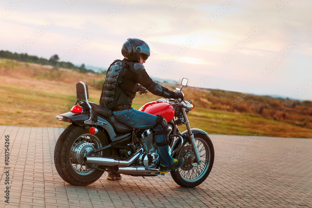Biker man wearing a leather jacket and sunglasses sitting on his motorcycle Biker man wearing a leather jacket and sunglasses sitting on his motorcycle