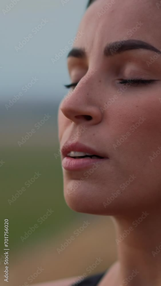 Head shot portrait of young peaceful woman breathing fresh air, enjoying deep meditation with closed eyes Head shot portrait of young peaceful woman breathing fresh air, enjoying deep meditation with closed eyes