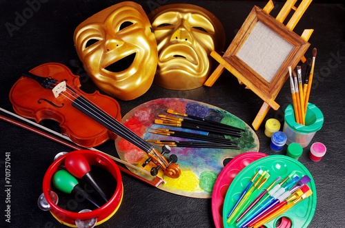 Attributes of the arts. Painting, music, theater. Canvas, palette, brushes, paints. Violin, bow, tambourine, maracas. Masks of tragedy and comedy. photo