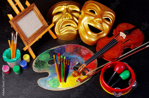 Attributes of the arts. Painting, music, theater. Canvas, palette, brushes, paints. Violin, bow, tambourine, maracas. Masks of tragedy and comedy.