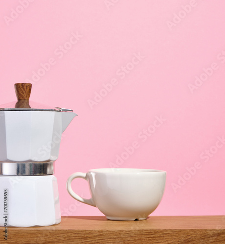 Italian metallic coffee maker and cup of hot coffee. Copy space for text. photo
