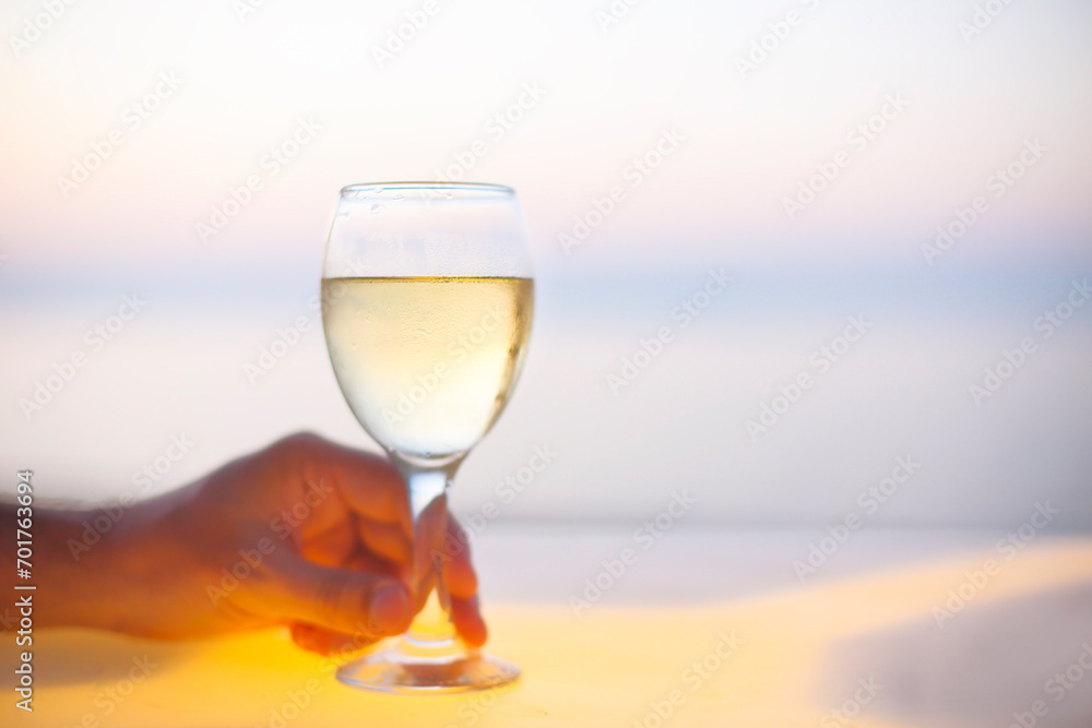 Relaxing man with glass of white wine on the beach