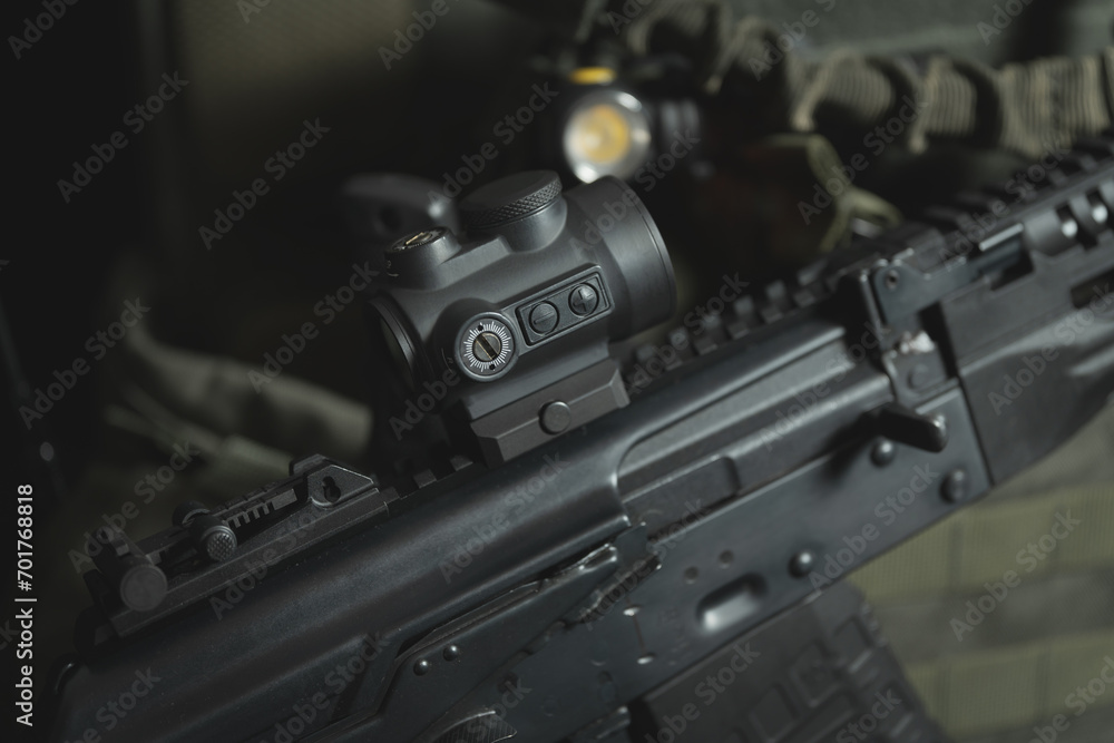 A modern red dot sight is installed on an AK 12, close-up photo. A modern red dot sight is installed on an AK 12, close-up photo.