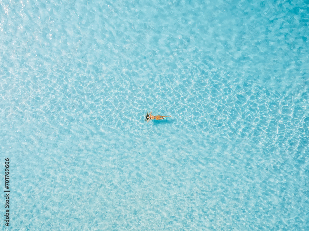 Woman floating and relaxing in blue sea. Aerial view, top view. Woman floating and relaxing in blue sea. Aerial view, top view.