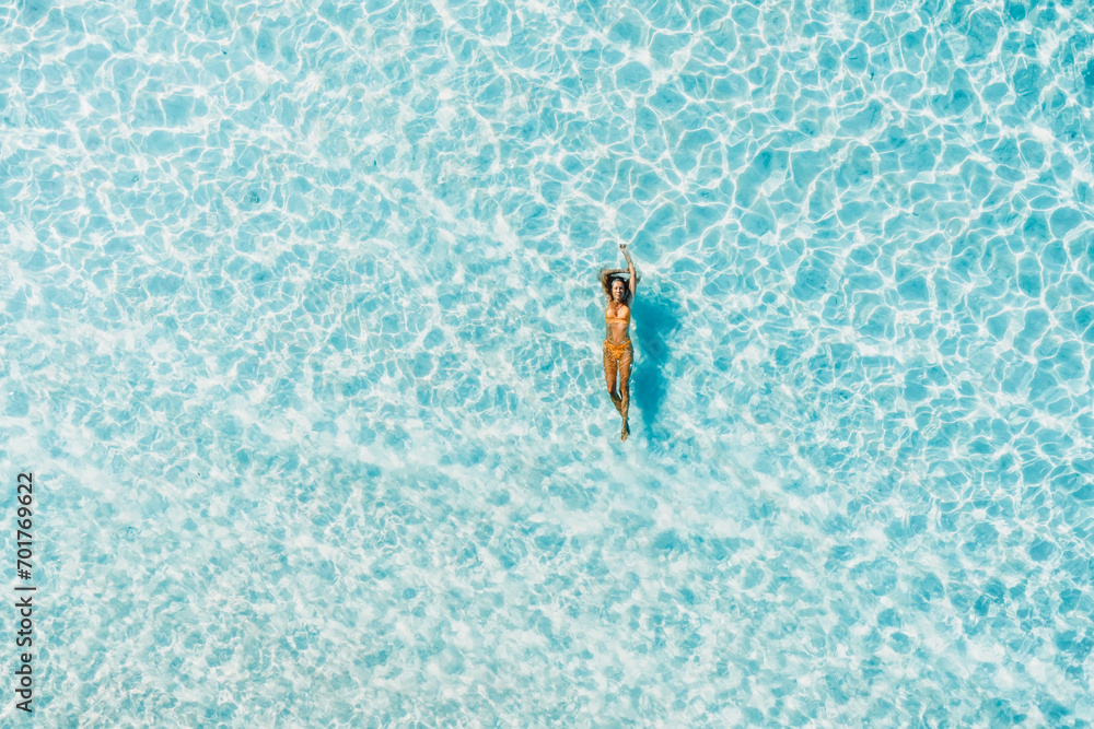 Beautiful woman swimming in blue ocean. Aerial top view