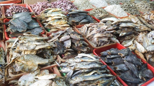 Various kinds of salted fish in containers at a traditional market