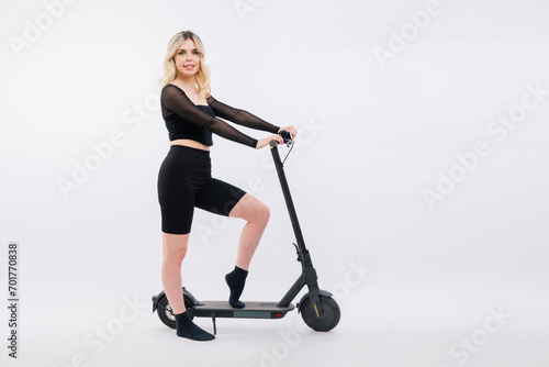 Happy young woman wear glasses riding electric scooter on background studio People lifestyle concept