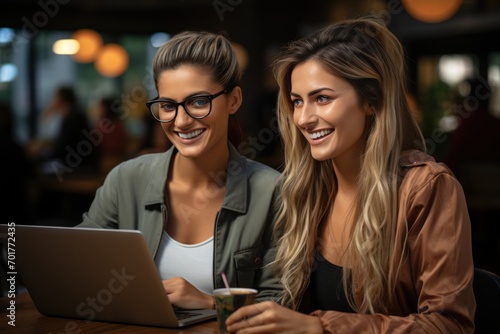 Happy business women sitting together focused on a laptop, business meeting image