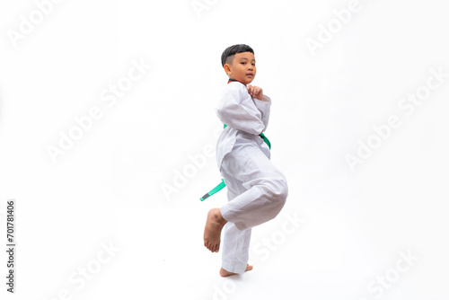 Practice Kick. kids karate martial arts. Taekwondo uniform with green belt. Portrait Thai Asian school boy isolated on white background banner. Action sport training concept