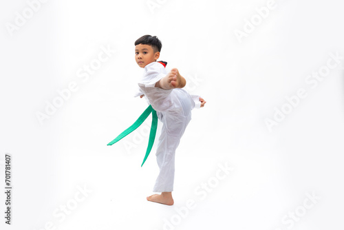 Practice Kick. kids karate martial arts. Taekwondo uniform with green belt. Portrait Thai Asian school boy isolated on white background banner. Action sport training concept