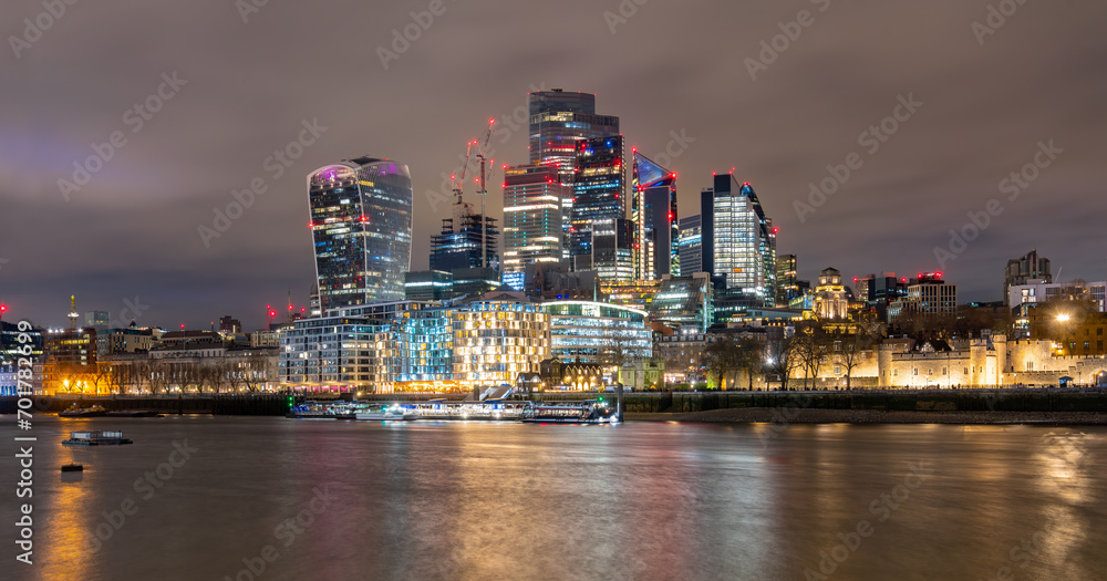 Night time panorama with the skyline of modern City of London, Thames river near tower castle with colorful illumination and water reflection. Capital of England with landmarks, sights at Tower Bridge Night time panorama with the skyline of modern City of London, Thames river near tower castle with colorful illumination and water reflection. Capital of England with landmarks, sights at Tower Bridge
