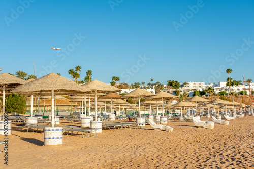 Chairs under umbrellas on tropical beach. Summer vacation concept.