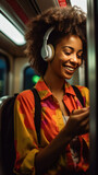 African American woman passenger listening music via smart mobile phone in a train, Smile female wearing wireless headphones while moving in the tram.