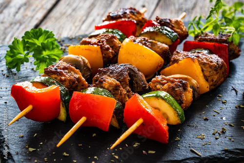 Meat skewers - grilled meat with vegetables on wooden background
 photo