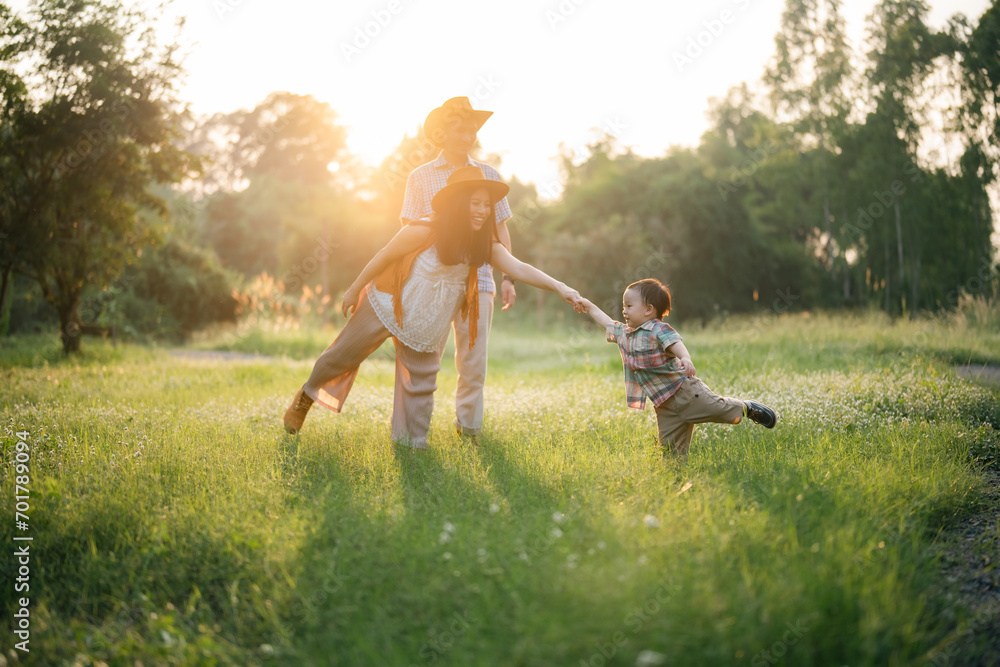 Obraz premium happy harmonious Asian family outdoors concept, Asian mother and son have activities happy fun together on holidays, grass land with sunlight