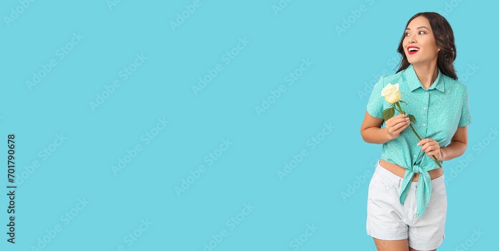 Beautiful young woman holding rose on light blue background with space for text Beautiful young woman holding rose on light blue background with space for text