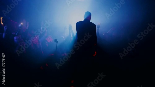 Rock concert at the club. Night club party. The rock band plays at the rock festival. People raised their hands up and listen to rock. preacher, religion, messiah, sect photo