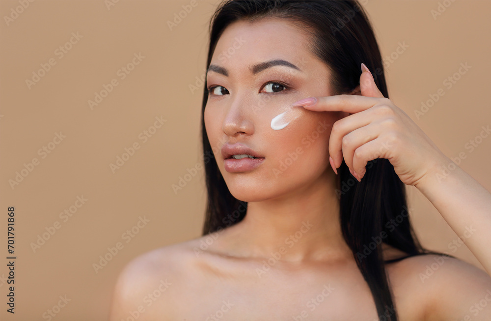 Beauty portrait of young attractive asian woman with face cream Beauty portrait of young attractive asian woman with face cream