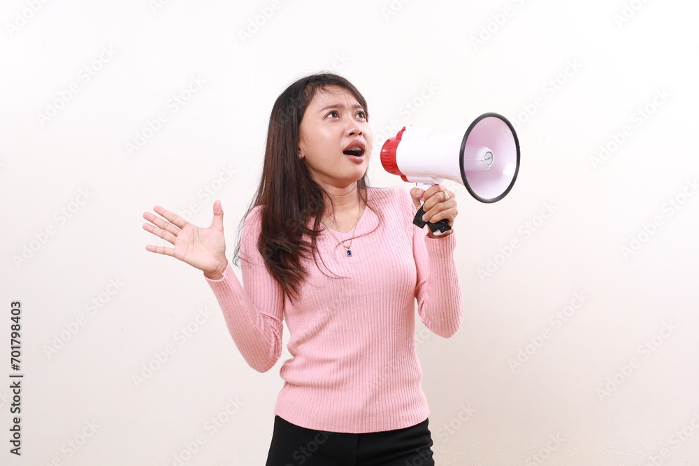 Confused young asian girl standing using megaphone while looking above. Advertisement and Promotional concept. Isolated on white background Confused young asian girl standing using megaphone while looking above. Advertisement and Promotional concept. Isolated on white background