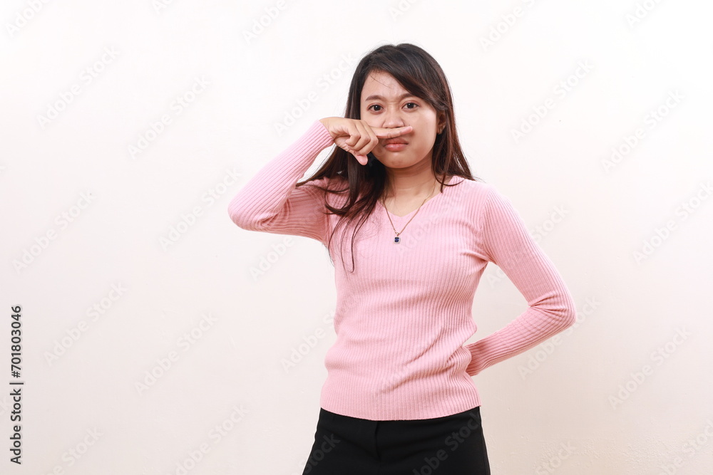 Young asian girl standing while covering her nose. Bad smell concept. Isolated on white background Young asian girl standing while covering her nose. Bad smell concept. Isolated on white background