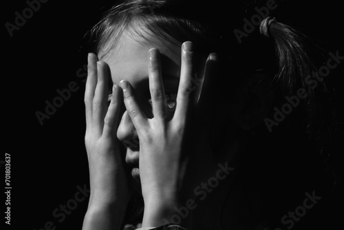 Close up portrait of crying young girl. Loneliness, depression, pain, child tragedy. Black and white image. Horizontal image.